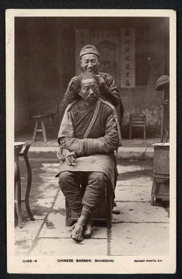 photographie en noir et blanc d'un vieil homme assis sur une chaise à côté d'une femme