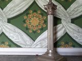 une lampe posée sur un socle devant un mur