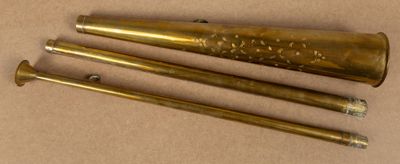 three brass baseball bats sitting on top of a brown surface