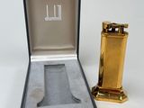 un briquet doré dans une boîte noire, à côté d'un autre briquet doré