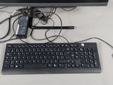 un clavier et une souris posés sur un bureau, à côté d'un écran