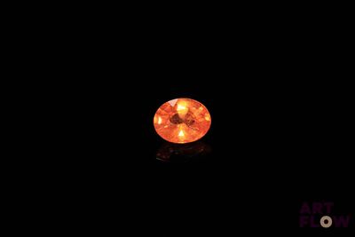 un gros plan sur un diamant orange dans l'obscurité