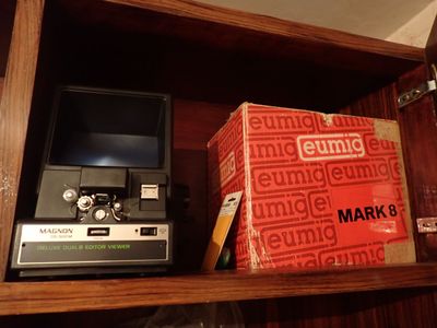 une télévision et un coffret posés sur une étagère dans une pièce