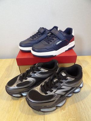a pair of black and silver running shoes on top of a red box
