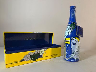 une bouteille de vin posée sur une table à côté d'une boîte