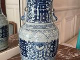 a blue and white vase sitting on a table in front of a mirror