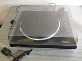 une platine posée sur une table, sur laquelle se trouve un chargeur