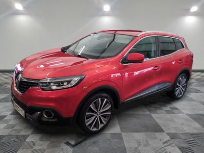 un SUV Renault rouge garé sur un sol à damier dans un garage