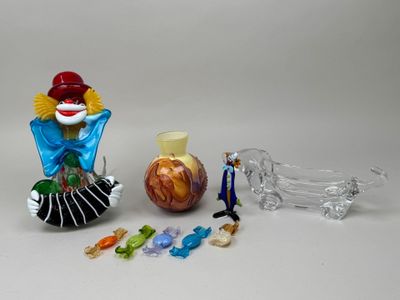 a figurine of a clown and a glass vase on a table