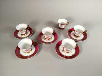 six tasses et soucoupes sont posées sur une table