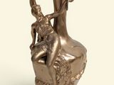 a bronze statue of a woman sitting on a vase