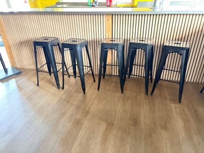 quatre tabourets noirs placés devant un comptoir