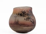 a glass vase with a tree on it on a white surface