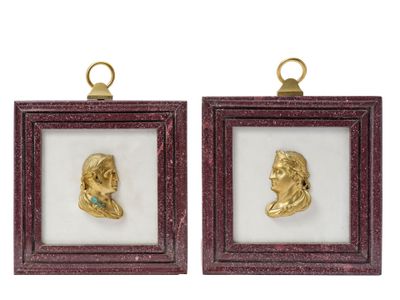 a pair of gold - plated busts of a man and a woman