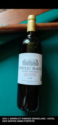 une bouteille de vin posée sur une table à côté d'un billard