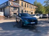 a blue car parked in front of a building with a sign on it