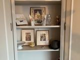a shelf with pictures and pictures on it in the corner of a room