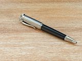 a pen that is laying on a wooden table