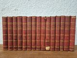 several old books are lined up on a wooden table