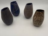 five vases that are sitting on a white surface