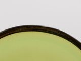a close up view of a green bowl with a black rim