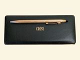 black wallet with a pen on top of it with the word cross written on it