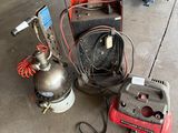 two air compressors on the ground next to a machine