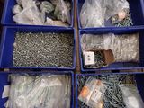many different types of screws and nuts in the bins