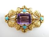 une image représentant une broche ornée d'une pierre violette entourée de pierres turquoise