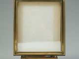 an old picture frame sitting on top of a wooden stand