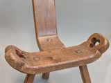 une chaise en bois posée sur une surface blanche