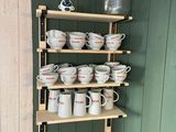 de nombreuses tasses et soucoupes sur les étagères de la cuisine