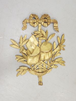 a gold plate with a bird and flowers on it