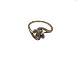 un gros plan d'une bague en or ornée de perles sur fond blanc