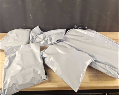 plusieurs sacs en plastique argenté posés sur une table en bois