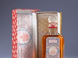 a small bottle of perfume sitting next to a box
