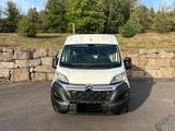 a white van parked in a parking lot near a stone wall