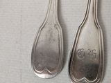 two spoons that are sitting next to each other on a table