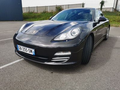 the black porsche panamer is parked in a parking lot