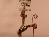 a metal sculpture of a man holding a cane