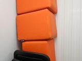 a stack of orange chairs in a room with a radiator