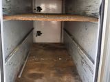 a small white box with shelves inside of it