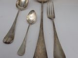 five silver spoons and two silver spoons on a white table