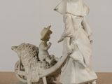 a figurine of a woman and a sheep on a table