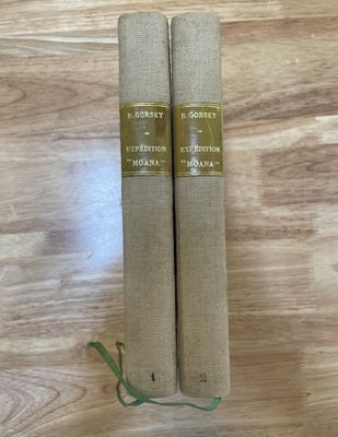 deux livres posés sur une table en bois, ornée d'un ruban vert