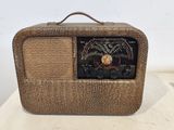 an old radio sitting on top of a wooden table next to a white wall