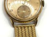 une image d'un gros plan d'une montre-bracelet sur une surface blanche