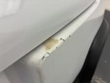a white car with rust on the side of it