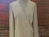 the jacket is on a mannequin stand in front of a woven wall