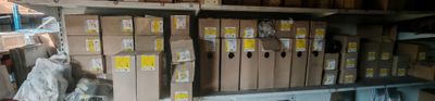 many boxes that are stacked on a shelf in a room